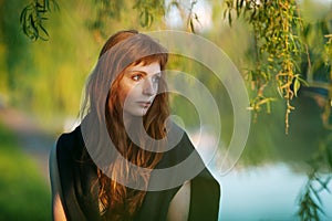 Young redhead caucasian woman serious face outdoor portrait in film retro colors