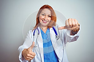 Young redhead doctor woman using stethoscope over white isolated background approving doing positive gesture with hand, thumbs up