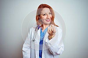 Young redhead doctor woman using stethoscope over white isolated background Beckoning come here gesture with hand inviting