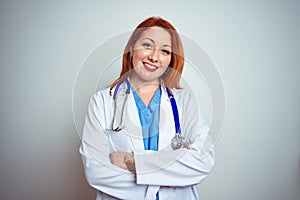 Young redhead doctor woman using stethoscope over white isolated background happy face smiling with crossed arms looking at the