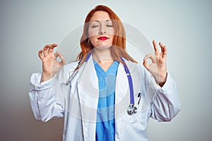 Young redhead doctor woman using stethoscope over white isolated background relaxed and smiling with eyes closed doing meditation