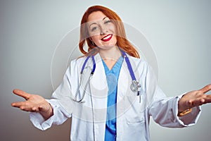 Young redhead doctor woman using stethoscope over white isolated background smiling cheerful offering hands giving assistance and