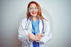 Young redhead doctor woman using stethoscope over white isolated background Smiling with hands palms together receiving or giving