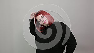 Young redhead fat lady in black sweater seductive woman touches hair with hand