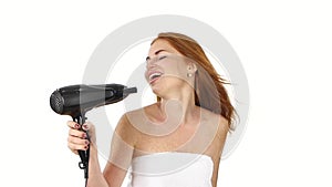 Young Redhead girl singing while blow-dry. Close