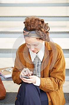 Young redhead hipster woman using smartphone