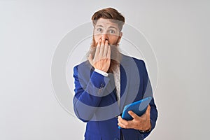 Young redhead irish businessman using tablet over isolated white background cover mouth with hand shocked with shame for mistake,