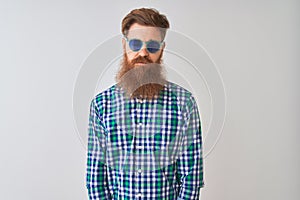 Young redhead irish man wearing casual shirt and sunglasses over isolated white background depressed and worry for distress,