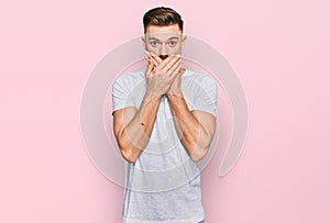 Young redhead man wearing casual grey t shirt shocked covering mouth with hands for mistake