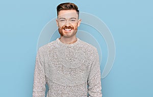 Young redhead man wearing casual winter sweater with a happy and cool smile on face