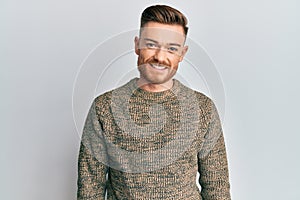 Young redhead man wearing casual winter sweater with a happy and cool smile on face