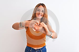 Young redhead modern woman over isolated background smiling in love showing heart symbol and shape with hands