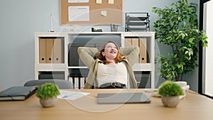 Young redhead woman business worker relaxed stretching arms at office