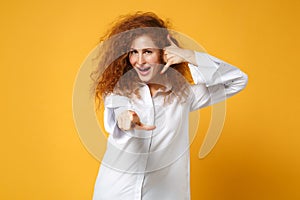 Young redhead woman girl in shirt posing isolated on yellow orange background. People lifestyle concept. Mock up copy