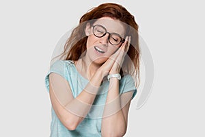 Young redhead woman resting on hands sleeping isolated on background