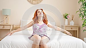 Young redhead woman smiling confident lying on bed at bedroom