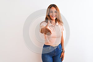 Young redhead woman stading over white isolated background smiling friendly offering handshake as greeting and welcoming