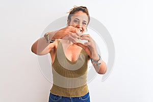 Young redhead woman wearing a bun over isolated background smiling in love doing heart symbol shape with hands