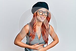 Young redhead woman wearing fashion french look with beret smiling and laughing hard out loud because funny crazy joke with hands