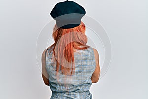 Young redhead woman wearing fashion french look with beret standing backwards looking away with crossed arms