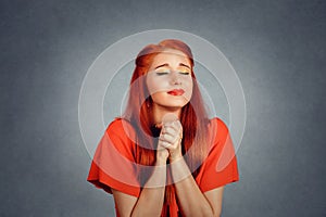 Young woman praying god for something eyes closed in hope