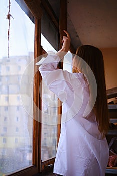 Young redhead Woman in white shirt closing The Window on the balcony Deep In Thought red hairs ginger girl general plane