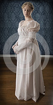 A young Regency woman in a pink dress and pearl necklace