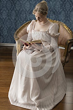 A young Regency woman in a pink dress and pearl necklace photo