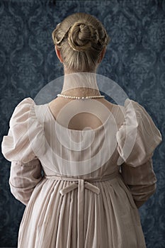 A young Regency woman in a pink dress and pearl necklace photo