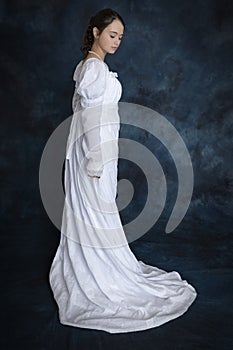 A young Regency woman wearing a white muslin dress and a pearl necklace