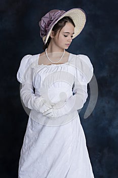 A young Regency woman wearing a white muslin dress, straw bonnet, and a pearl necklace