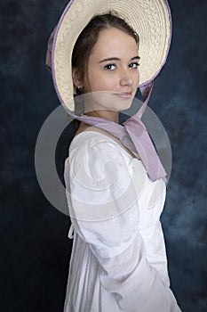 A young Regency woman wearing a white muslin dress, straw bonnet, and a pearl necklace