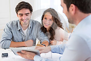 Young relaxed couple meeting a real estate agent photo