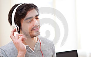 Young relaxed man listenning music at the office