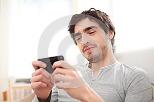 Young relaxed man writting text in the sofa photo