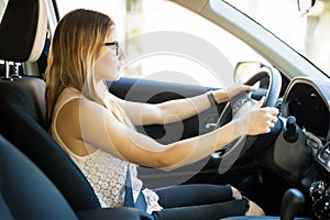 Young relaxed woman driving a car