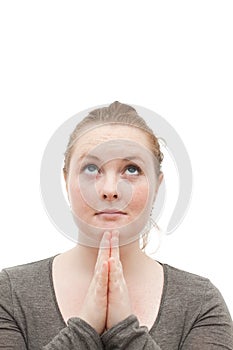 Young religious woman praying to god on white