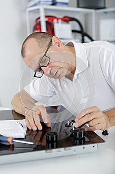 Young repair man installing kitchen hobs