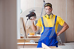 The young repairman carpenter working cutting wood on circular saw