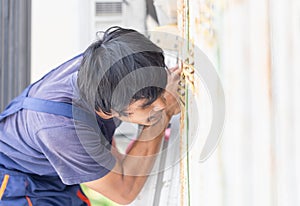 Young repairman fixing air conditioner unit, Technician man installing an air conditioning in a client house