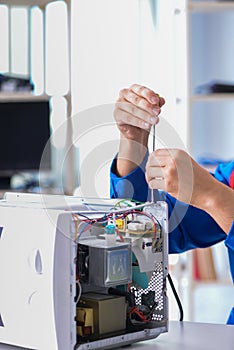 The young repairman fixing and repairing microwave oven