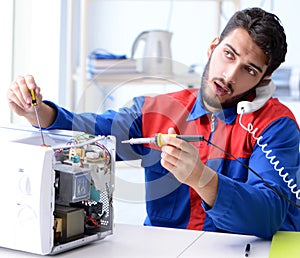 Young repairman fixing and repairing microwave oven