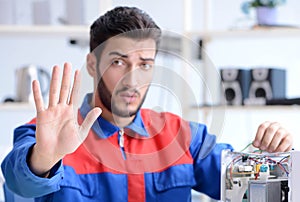 Young repairman fixing and repairing microwave oven