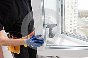 Young repairman fixing window frame in room at daytime