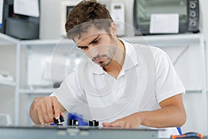 young repairman installing induction cooker in kitchen