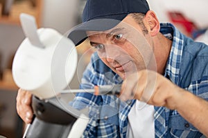 young repairman service worker repairing appliance