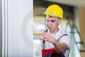 The young repairman with tape measure working on repairs