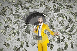 Young rich businessman standing in money rain