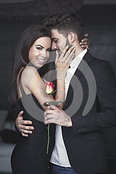 Young rich romantic couple with rose on dating