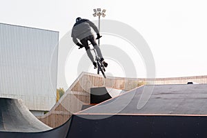 A young rider on a BMX bike does tricks in the air